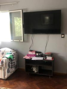 Zimmer mit einem TV an der Wand und einem Tisch in der Unterkunft Casa Pilar in Yerba Buena