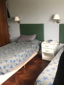 um quarto com 2 camas individuais e uma mesa de cabeceira em Casa Pilar em Yerba Buena