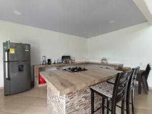 a kitchen with a counter and a refrigerator at Fresca casa de descanso en La Jagua in Garzón