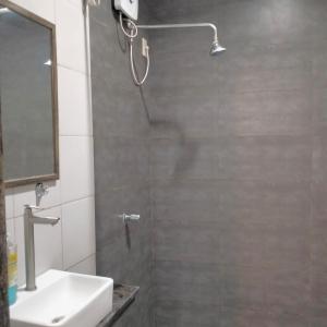 a shower with a shower head and a sink in a bathroom at Full House in El Nido
