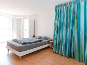 um quarto com uma cama com cortinas azuis e verdes em Villa Fleury-Saint-Pierre-la-Mer, 4 pièces, 6 personnes - FR-1-409-188 em Fleury