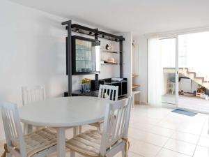 uma sala de jantar com uma mesa branca e cadeiras em Villa Fleury-Saint-Pierre-la-Mer, 4 pièces, 6 personnes - FR-1-409-188 em Fleury