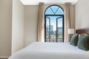 a bedroom with a bed and a large window at Frome Apartments in Adelaide