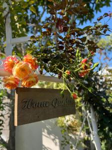 保祿的住宿－HomeTa Homestay，上面有花卉的家花园的标志
