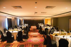 a banquet hall with tables and chairs and tablesktop at Brittany Hotel BGC in Manila