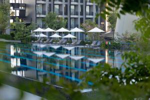 a swimming pool with chairs and umbrellas next to a building at VARANA Hotel Krabi in Klong Muang Beach