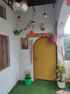 a room with a yellow door and some plants at Manavi Home Stay in Mathura