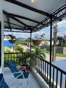 a balcony with two chairs and two potted plants at Jerusalén in Mariquita