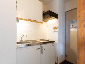 eine kleine Küche mit weißen Schränken und einer Spüle in der Unterkunft Studio 4 pers, 50m navette pistes, commerces proches - FR-1-695-49 in Germ