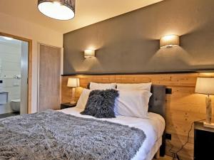 een slaapkamer met een groot bed met 2 verlichting aan de muur bij Appartement Huez, 2 pièces, 2 personnes - FR-1-645-60 in Huez