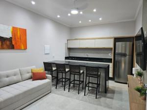 een woonkamer met een bank, een tafel en stoelen bij Flat Riviera de São Lourenço in Riviera de São Lourenço