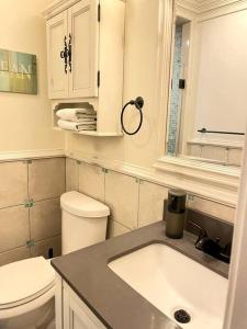 Baño blanco con lavabo y aseo en Paradise Home l Retreat & Event, en Sullivan