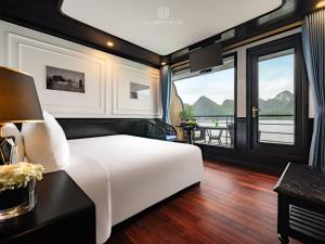 1 dormitorio con cama blanca y ventanas grandes en La Casta Cruise, en Ha Long