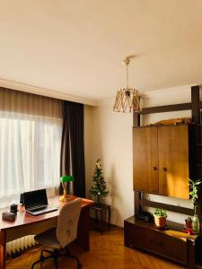 ein Zimmer mit einem Schreibtisch mit einem Laptop und einem Weihnachtsbaum in der Unterkunft Ankara Merkezde Piyanolu Daire in Ankara