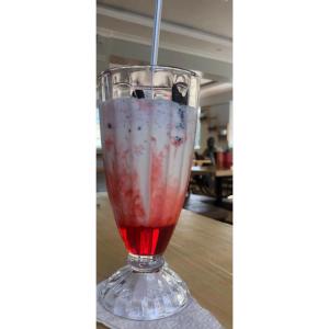 un drink in un bicchiere con una cannuccia dentro di Mt. Everest Hotel a Kisii
