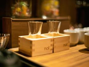 deux verres vides sur un bloc en bois sur une table dans l'établissement nol kyoto sanjo, à Kyoto