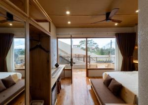 Kon Von KlaにあるMăngDiang Boutique Hotelのベッド2台とバルコニー付きのベッドルーム
