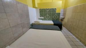 um pequeno quarto com 2 camas numa casa de banho em Pousada Bomfim em Maceió