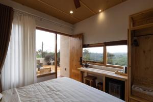 1 dormitorio con cama y ventana grande en MăngDiang Boutique Hotel, en Kon Von Kla