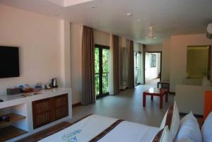 ein Hotelzimmer mit einem Bett und einem Wohnzimmer in der Unterkunft Allezboo Beach Resort & Spa in Mui Ne