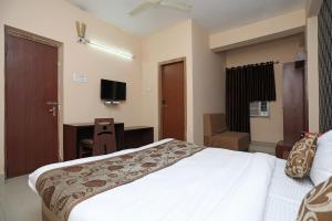 a hotel room with a bed and a television at Collection O Hotel Greenpark in Jamshedpur