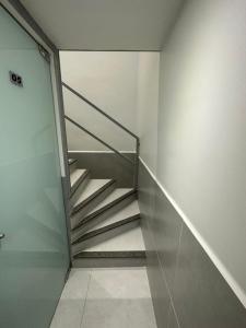 uma escada de metal num quarto com paredes brancas em Quarto privativo com banheiro compartilhado em Pousada recém construída,a 500mts do pátio do forró em Caruaru