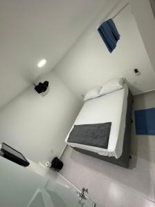 a small white room with a bed in the ceiling at Quarto privativo com banheiro compartilhado em Pousada recém construída,a 500mts do pátio do forró in Caruaru