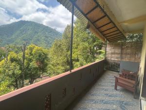 a balcony with a bench and a view of a mountain at Sugi Gede Homestay in Singaraja