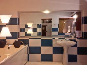 a bathroom with a sink and a tub and a mirror at Cabañas Villa Encanto in Villa de Leyva