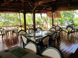 a group of tables and chairs on a wooden deck at Eskapo Verde Lodge Moalboal in Badian