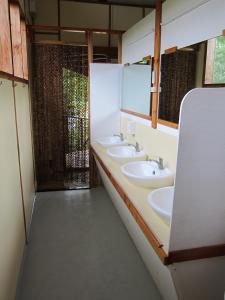 a bathroom with three sinks and two mirrors at Eskapo Verde Resort Moalboal in Badian