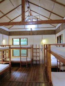 a room with three bunk beds and two windows at Eskapo Verde Resort Moalboal in Badian