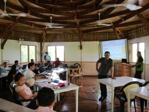 un grupo de personas sentadas en mesas en un aula en Eskapo Verde Resort Moalboal en Badian