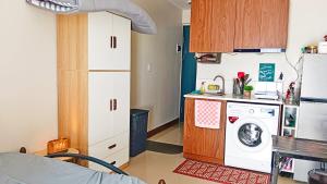 a small kitchen with a washing machine and a sink at Private studio unit with balcony near the beaches in Lapu Lapu City