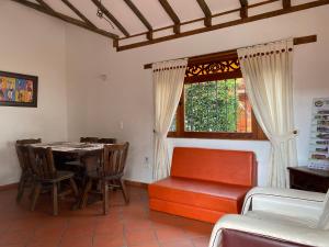 comedor con mesa, sillas y ventana en Cabañas Villa Encanto, en Villa de Leyva