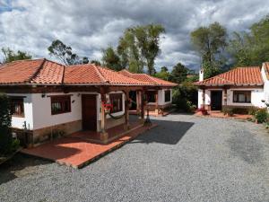 una casa con una entrada de grava delante de ella en Cabañas Villa Encanto, en Villa de Leyva
