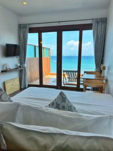 a bedroom with a bed and a view of the ocean at Akina Beach Resort KohLarn อกินะบีช รีสอร์ทเกาะล้าน in Ko Larn