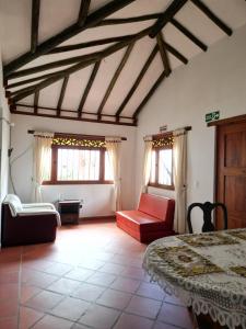 a bedroom with a bed and a couch and windows at Cabañas Villa Encanto in Villa de Leyva