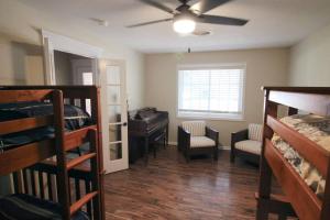 a room with bunk beds and a bedroom with a ceiling fan at Cozy Aggieland Vacay in Bryan