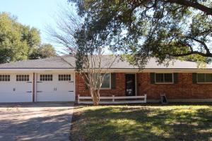 a brick house with two white garage doors at Cozy Aggieland Vacay in Bryan