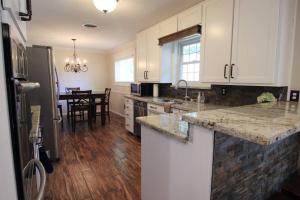a kitchen with white cabinets and a kitchen with a table at Cozy Aggieland Vacay in Bryan