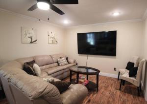 a living room with a couch and a flat screen tv at Cozy Aggieland Vacay in Bryan