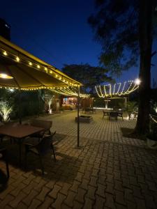 a patio with a table and umbrella at night at Premier Lodge in Dimāpur