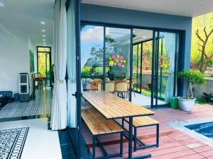 een veranda met een houten bank op een patio bij Villa 3 bedrooms Venus resort by Flamingo F12 or F24 in Thanh Cao