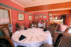 a dining room with a white table and chairs at Queenstown Motor Lodge in Queenstown