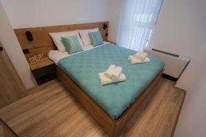a small bedroom with a bed with shoes on it at Lynx Apartment in Mavrovo