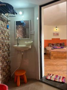布吉的住宿－Kutch kutir，一间带水槽的浴室和一张位于客房内的床