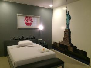 una stanza con un letto con la statua della libertà sul muro di GC Suites a Cagayan de Oro