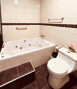 a bathroom with a white tub and a toilet and a sink at Amplia, independiente y segura vivienda de 2 habitaciones in Machala