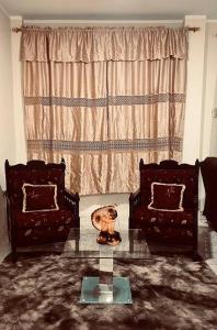 a living room with two chairs and a glass table at Amplia, independiente y segura vivienda de 2 habitaciones in Machala